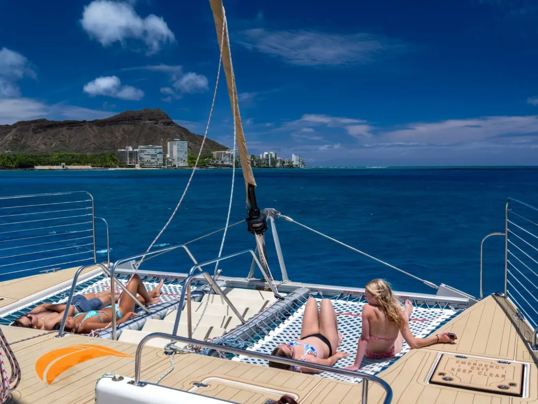 The bow nets under sail, Diamond Head and the Waikiki shoreline beyond
